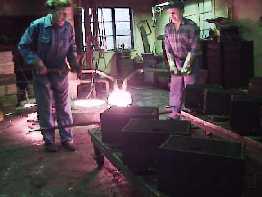 Bell makers prepare to pour the melted bronze into the bell dies